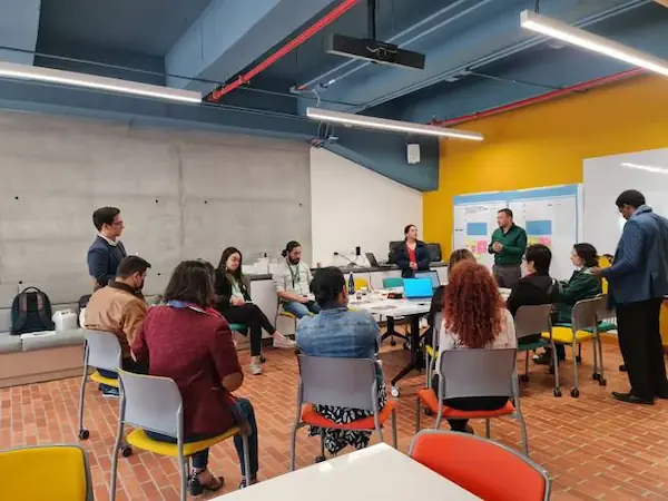Docentes y estudiantes en un taller discutiendo soluciones digitales para la educación