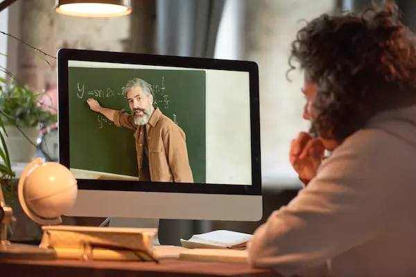 Hombre estudiando en línea con una laptop, concentrado en su trabajo